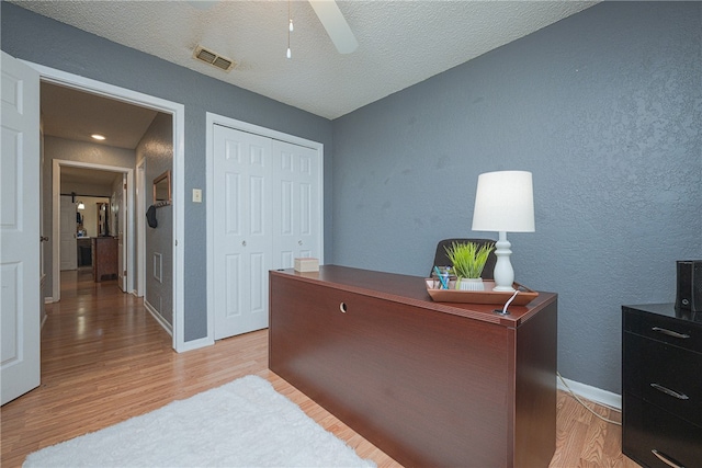 home office featuring ceiling fan, a textured ceiling, and light hardwood / wood-style flooring