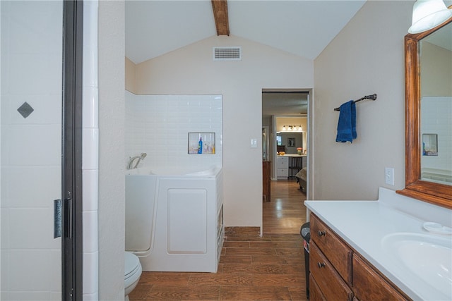 bathroom with vaulted ceiling with beams, toilet, hardwood / wood-style flooring, vanity, and a tub to relax in