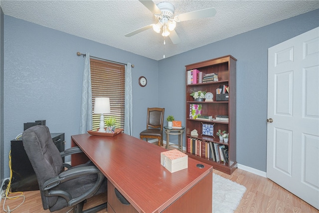 office area featuring light wood-type flooring, a textured ceiling, and ceiling fan