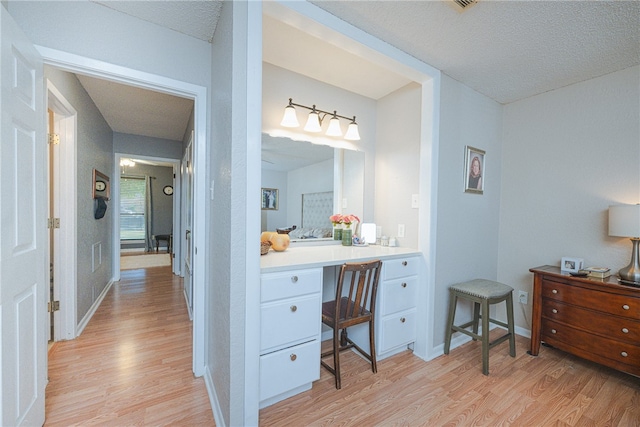 bathroom with vanity, wood-type flooring, and a textured ceiling