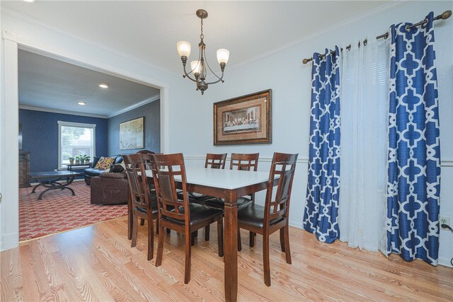 dining space featuring light hardwood / wood-style flooring, a notable chandelier, and crown molding