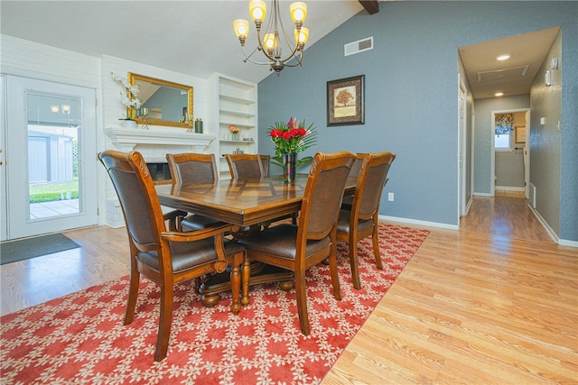 dining area with a chandelier, lofted ceiling, and hardwood / wood-style flooring