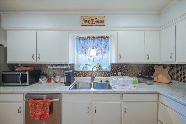 kitchen featuring tasteful backsplash, white cabinetry, appliances with stainless steel finishes, and sink