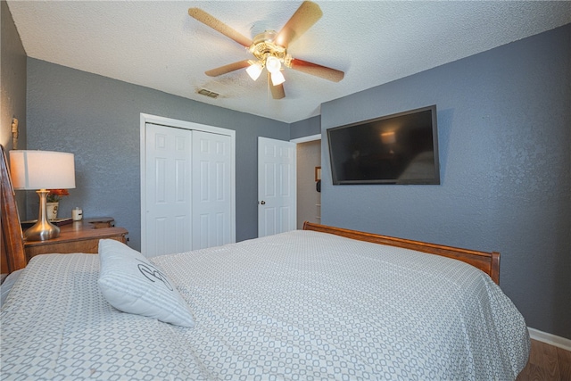 bedroom featuring hardwood / wood-style floors, ceiling fan, a textured ceiling, and a closet