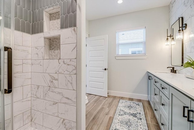 1911 Eskridge Rd, Port Aransas, TX 78373 - bathroom with double vanity, tiled shower, wood finished floors, and recessed lighting