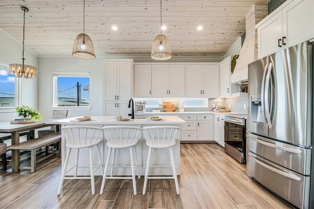 1911 Eskridge Rd, Port Aransas, TX 78373 - kitchen with stainless steel appliances, wooden ceiling, light countertops, white cabinetry, and light wood-style floors