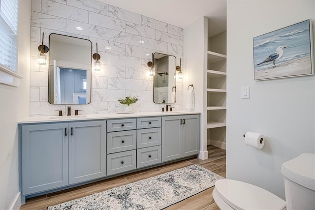 1911 Eskridge Rd, Port Aransas, TX 78373 - full bath featuring double vanity, wood finished floors, tasteful backsplash, and tiled shower