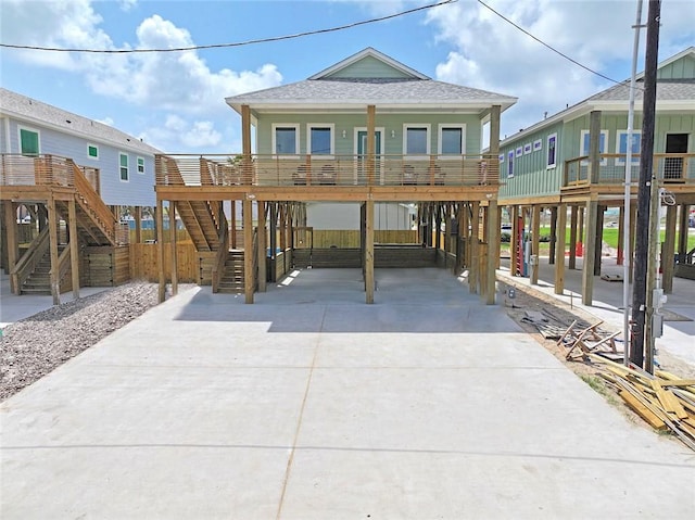 1911 Eskridge Rd, Port Aransas, TX 78373 - beach home with driveway, stairs, roof with shingles, and a carport