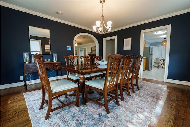 253 Melrose, Corpus Christi, TX 78404 - dining space featuring arched walkways, a chandelier, baseboards, wood finished floors, and ornamental molding