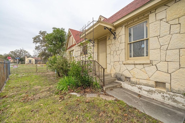 view of property exterior with crawl space, fence, and a lawn