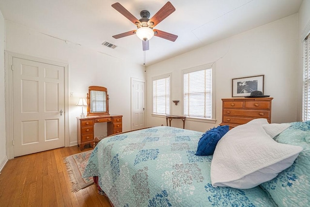 bedroom featuring light wood-type flooring, ceiling fan, visible vents, and a closet