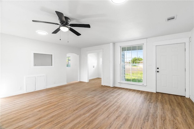 1601 Cambridge Dr, Corpus Christi, TX 78415 - unfurnished living room featuring light wood-style floors, arched walkways, and ceiling fan