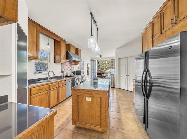 kitchen with pendant lighting, sink, a center island, stainless steel appliances, and wall chimney exhaust hood