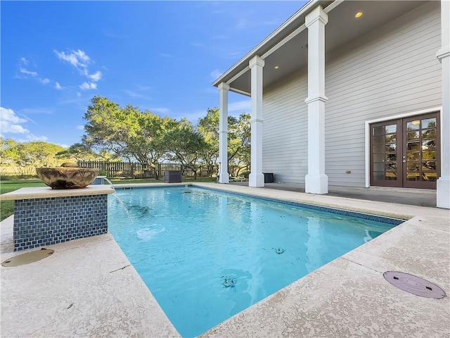 view of swimming pool with a patio, french doors, and pool water feature