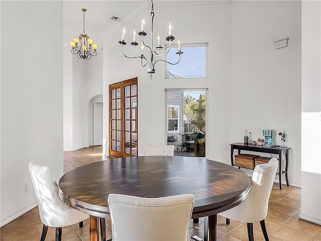 dining room featuring a high ceiling, light tile patterned flooring, and a notable chandelier