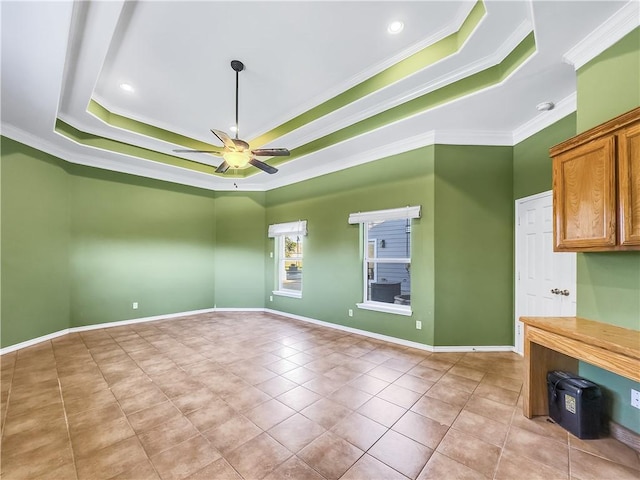 tiled empty room with crown molding, a tray ceiling, and ceiling fan