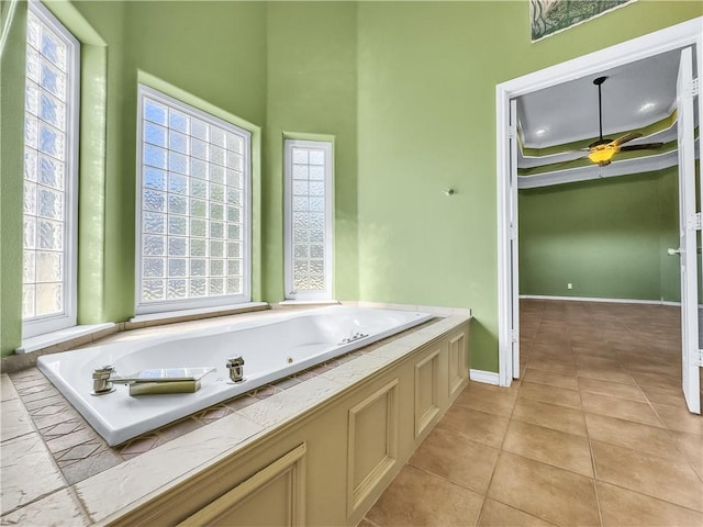 bathroom featuring ceiling fan, tile patterned flooring, and a washtub