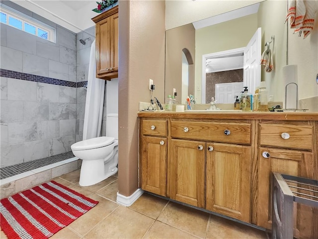 bathroom with vanity, tiled shower, tile patterned floors, and toilet