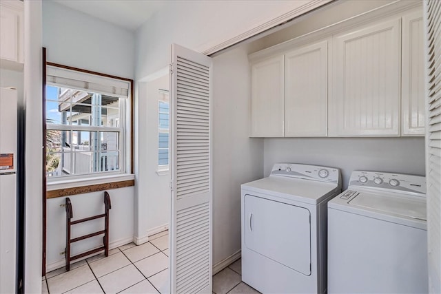 washroom with cabinets, separate washer and dryer, and light tile patterned floors