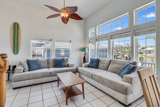 tiled living room featuring ceiling fan and a towering ceiling