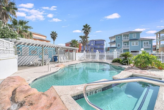 view of swimming pool featuring a hot tub, a pergola, and a patio area