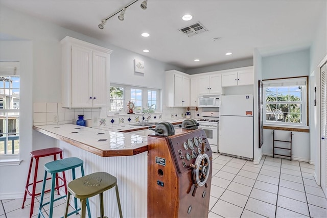 kitchen with tile counters, a wealth of natural light, and white appliances