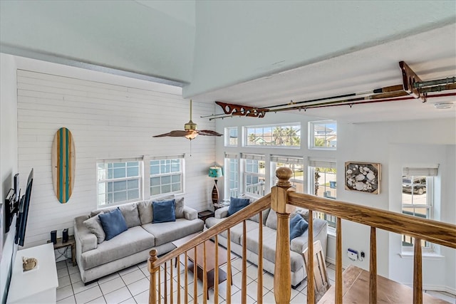 living room with light tile patterned flooring, lofted ceiling, and ceiling fan