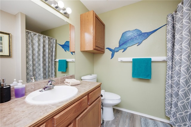 bathroom with toilet, vanity, and hardwood / wood-style floors