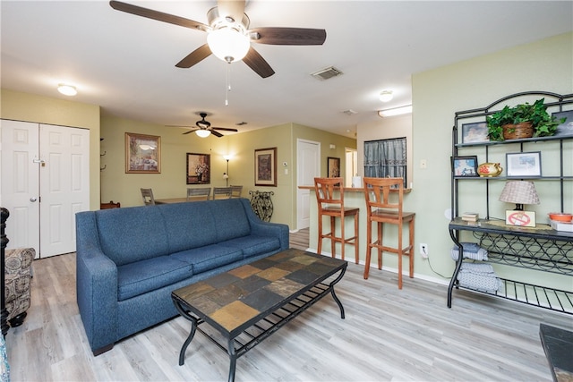 living room featuring light hardwood / wood-style flooring and ceiling fan