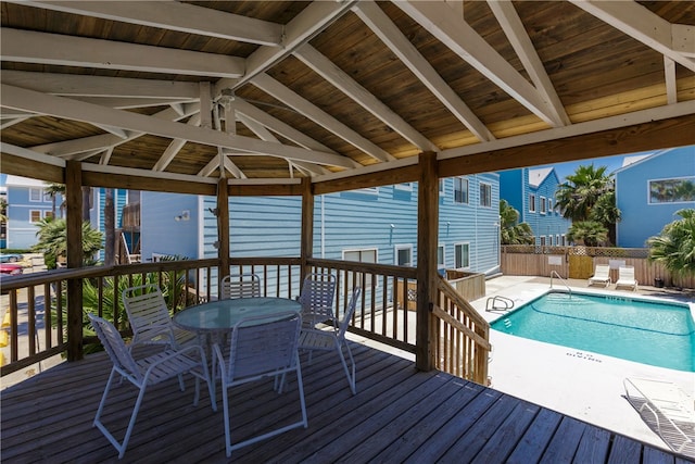 wooden deck with a community pool and a gazebo