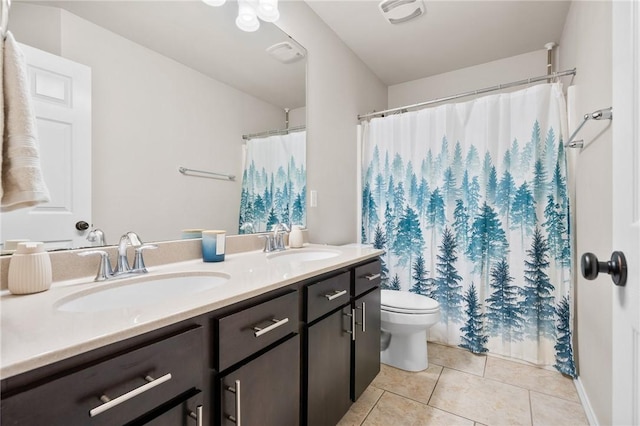 bathroom featuring vanity, toilet, and tile patterned flooring