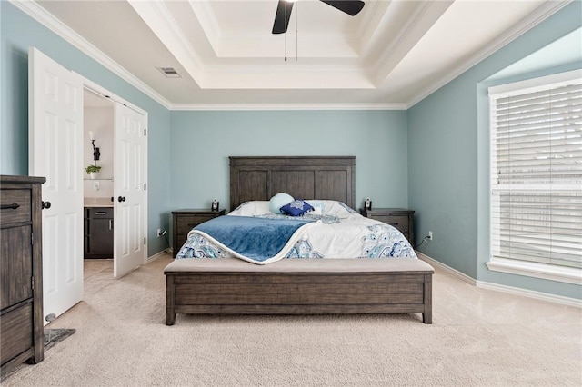 bedroom featuring multiple windows, ornamental molding, light colored carpet, and a raised ceiling