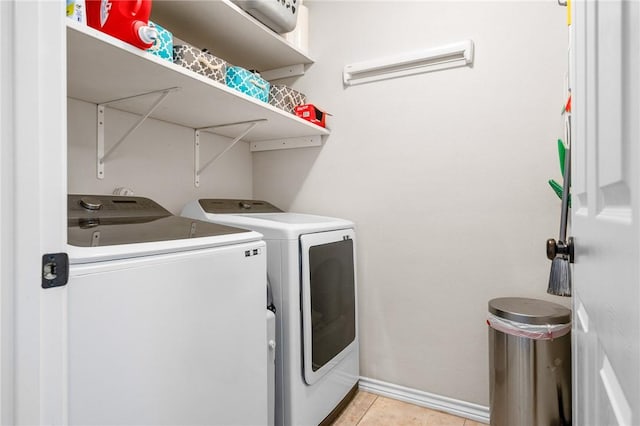 clothes washing area with light tile patterned floors and independent washer and dryer