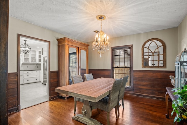 dining room featuring hardwood / wood-style flooring, a chandelier, and a textured ceiling