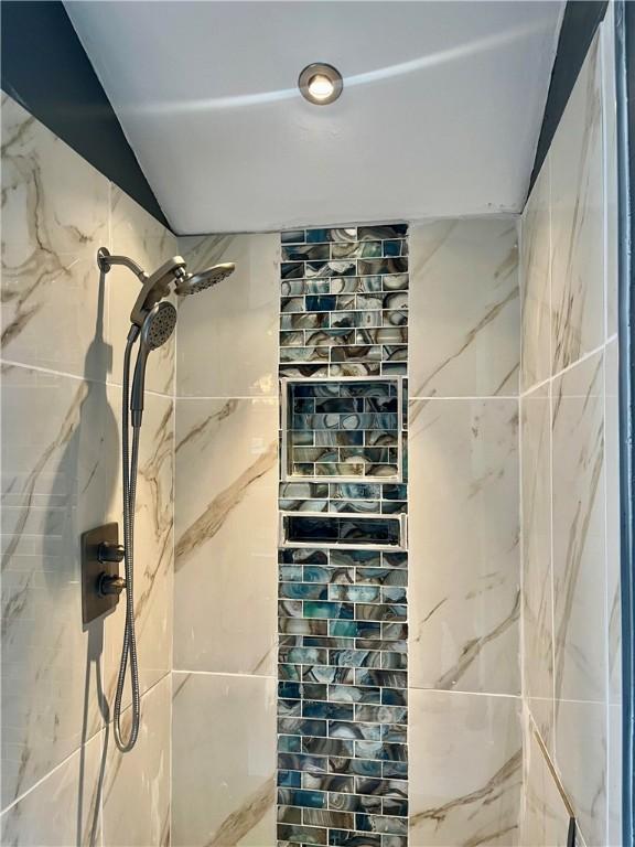 full bathroom featuring tiled shower