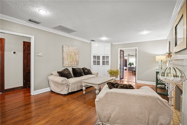 living room with ornamental molding, dark hardwood / wood-style flooring, and a textured ceiling