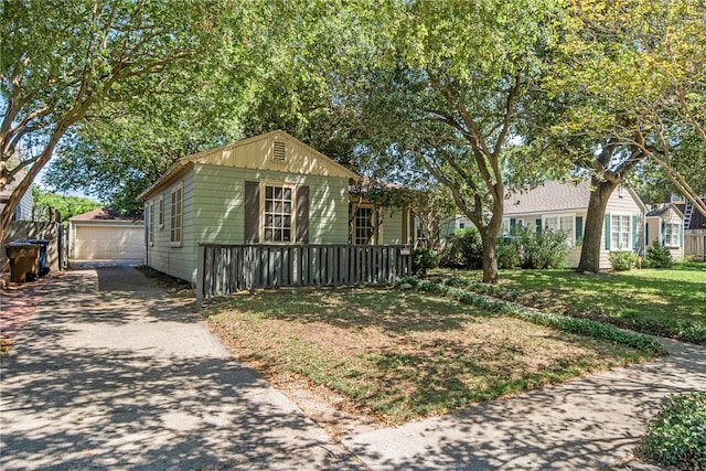 view of front of home with a garage, a front lawn, and an outbuilding