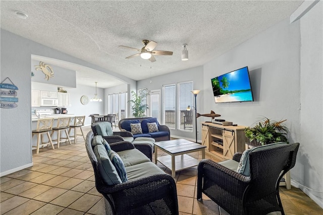 tiled living room featuring a textured ceiling and ceiling fan