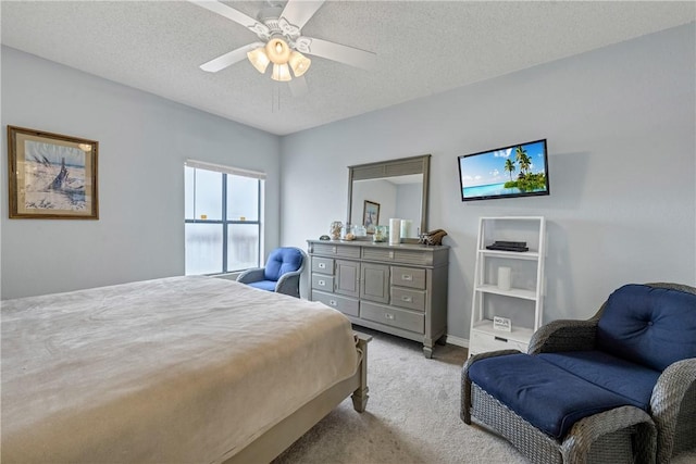 carpeted bedroom featuring ceiling fan and a textured ceiling