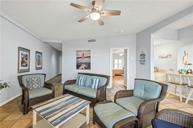 tiled living room featuring ceiling fan and a textured ceiling