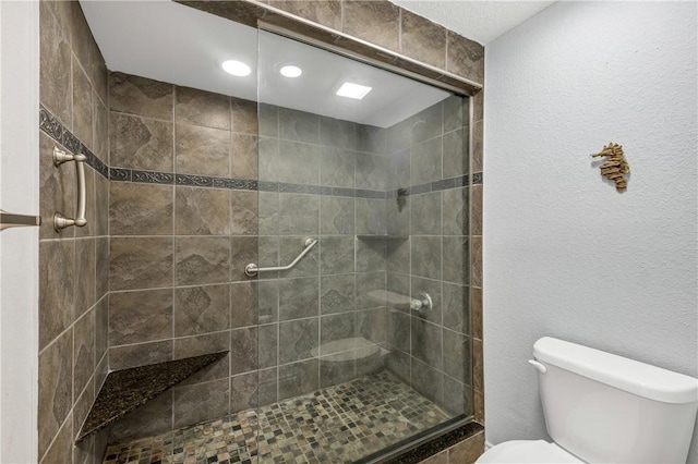 bathroom featuring a tile shower and toilet