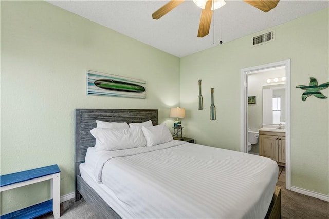 carpeted bedroom featuring ensuite bath and ceiling fan