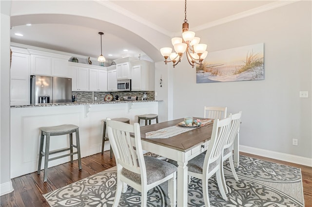 dining room featuring a chandelier, crown molding, and dark hardwood / wood-style flooring