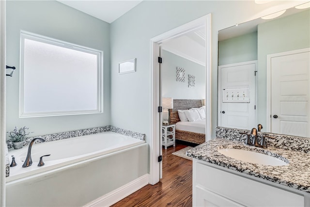 bathroom with a bathtub, vanity, and hardwood / wood-style flooring