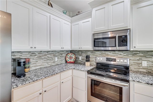 kitchen featuring white cabinetry, stainless steel appliances, tasteful backsplash, and light stone countertops