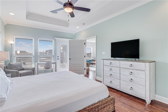 bedroom with ceiling fan, dark hardwood / wood-style flooring, and a tray ceiling