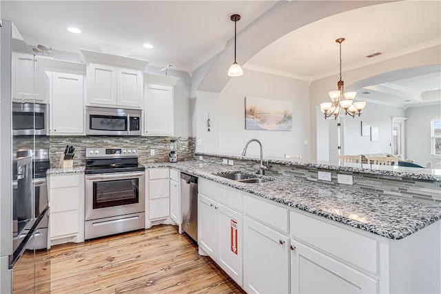 kitchen featuring white cabinets, hanging light fixtures, sink, and stainless steel appliances