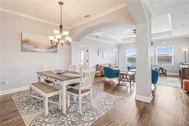 dining area featuring crown molding, ceiling fan with notable chandelier, dark hardwood / wood-style floors, and a raised ceiling