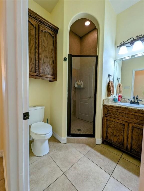 full bath featuring a stall shower, tile patterned flooring, vanity, and toilet