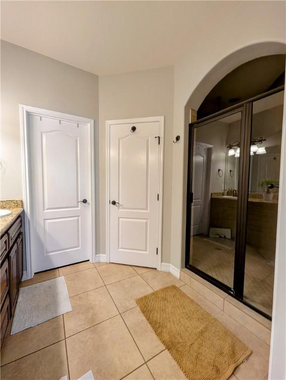 bathroom with vanity, baseboards, and tile patterned floors